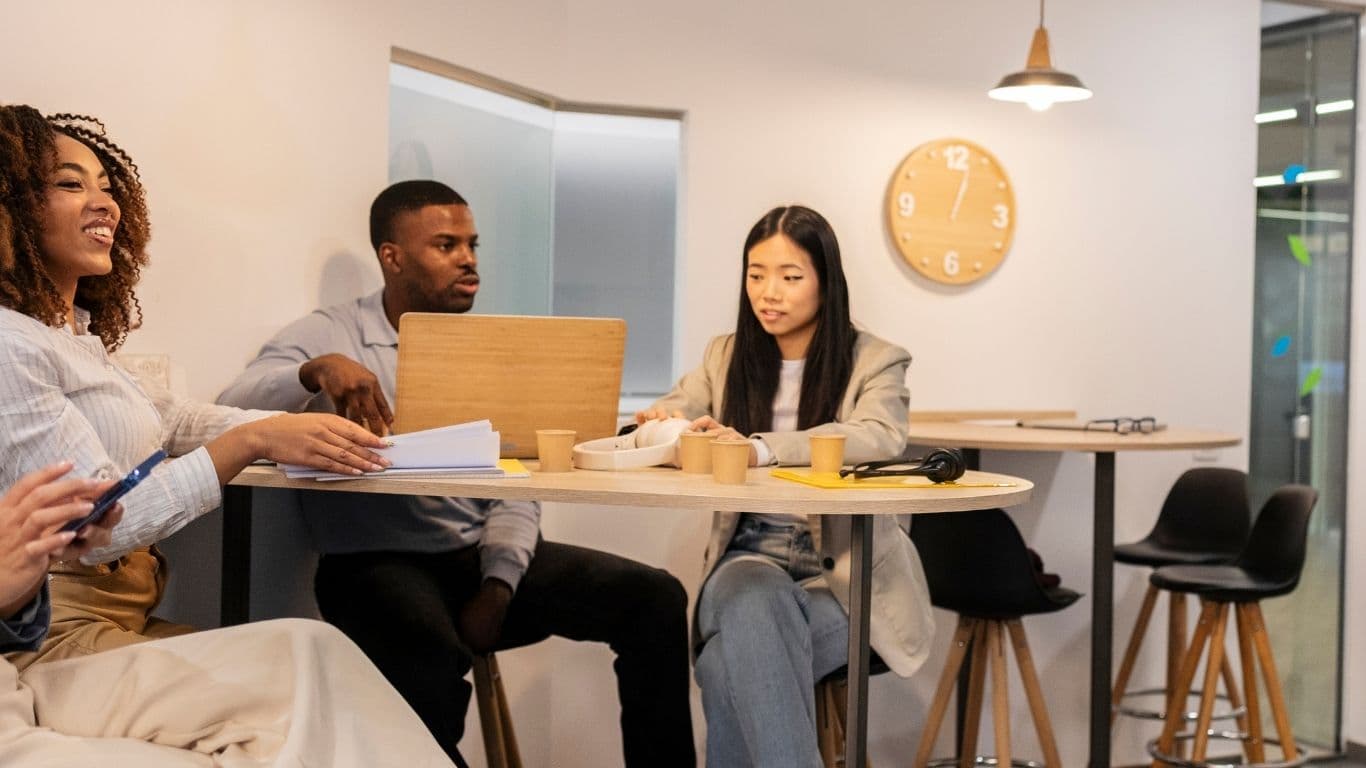 A sunlit moment of insight at a workspace, two professionals mid-conversation